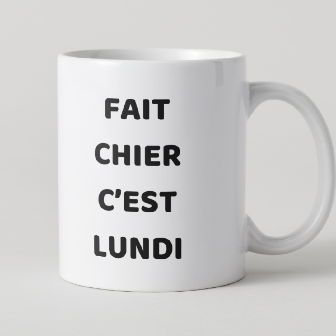 Mug blanc avec texte noir "Fait chier c'est lundi" et design épuré.